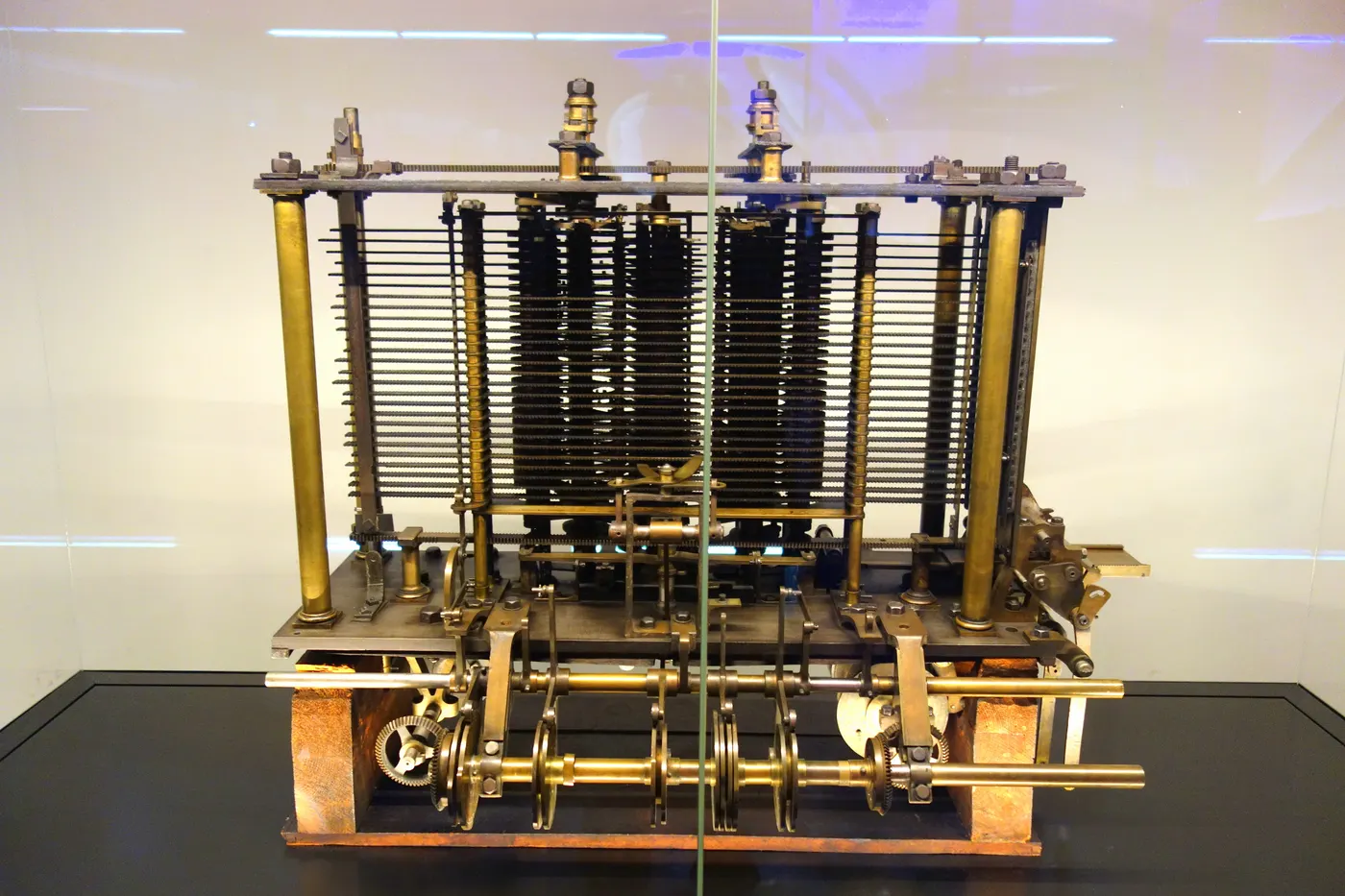 Een proefmodel van een deel van Babbages Analytical Engine: messing kolommen, tandwielen en stangen in een vitrine in het Science Museum in Londen